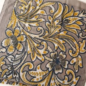 Detailansicht grauer Baumwoll-Leinen-Schal mit goldenem Blumendruck und Fransen