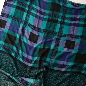 Vue détaillée du tissu de l'écharpe à carreaux bleus et verts avec texture douce et fluide