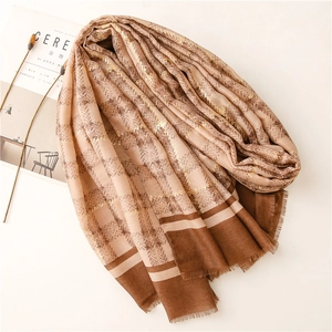 Detail of herringbone linen texture scarf with gold foil accents and frayed edges