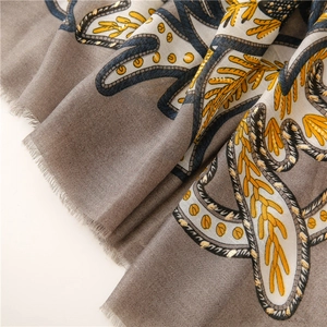 Detail eines dunkelbraunen Paisley-Paschminas mit Goldfoliendruck und Fischgrätenmuster