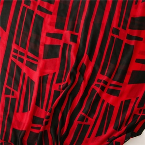 Detailed view of red and black geometric patterns on lightweight cotton linen scarf fabric