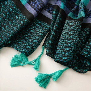 Détail d'une écharpe à motifs géométriques avec franges bleues et texture mosaïque douce