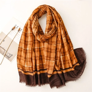 Detail of orange plaid scarf with long tassels and warm autumn texture display