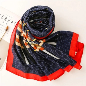 Detail of navy blue cotton linen scarf featuring luxury chain pattern and red borders