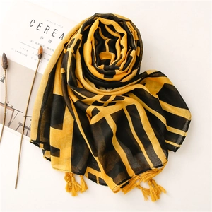 Detail of yellow and black geometric plaid scarf with bright fringe tassels on side