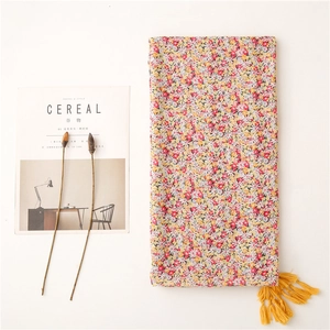 Floral print scarf with soft cotton feel featuring yellow tassels and pink flower patterns