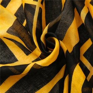 Detail of yellow and black geometric grid scarf showing cotton-linen woven texture