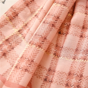 Detail of pink plaid scarf showing gold thread highlights and woven herringbone texture