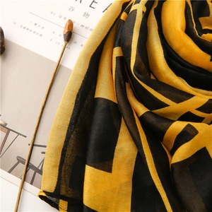 Macro shot of light-weight scarf with black and yellow geometric color block patterns
