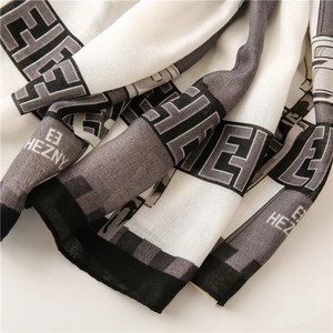 Detail of cotton linen scarf showing geometric letters print and premium edge stitching