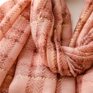 Close-up of pink herringbone cotton linen scarf with gold foil and dark brown plaid detail