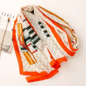 Detail of elegant white scarf with orange borders and intertwined geometric patterns