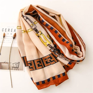 Detail view of cotton linen scarf featuring geometric chain patterns and vibrant orange borders