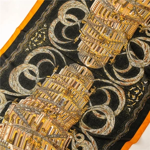 Detail of artistic cotton-linen scarf with intricate tower and bird pattern in black and orange