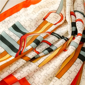 Detailed macro view of lightweight silk scarf fabric with chain patterns and horse bridle