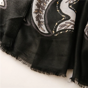 Nahaufnahme von Fischgrätenmuster mit Paisley-Druck und goldenen Stickereien am Schal