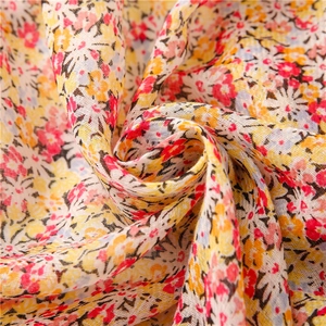 Close-up of lightweight floral fabric texture with soft yellow fringe tassels