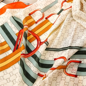 Detail of luxury cotton linen scarf with horsebit pattern and monogram print texture