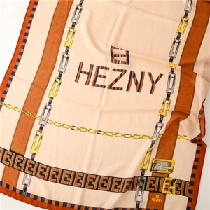Detailed close-up of light silk scarf featuring orange borders and elegant chain pattern