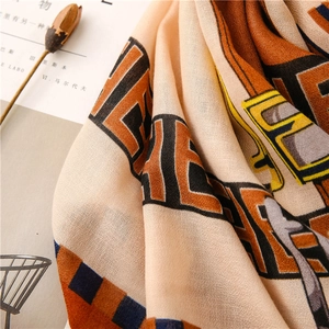 Close-up of geometric pattern printed scarf with beige and orange autumn texture