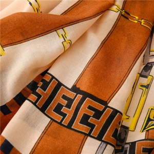Detail shot of cotton linen scarf showing belt chain print and soft fabric texture