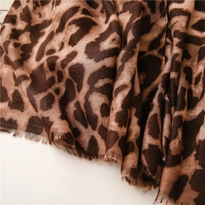 Detail of brown leopard print scarf with diagonal twill weave and frayed tassel edges