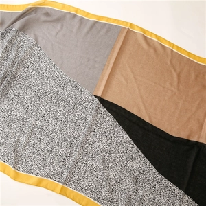 Detail of color block cotton linen scarf with geometric patterns and yellow stitching
