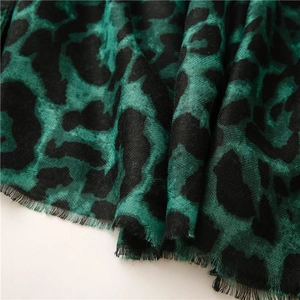 Detailed view of dark green and black leopard print scarf with soft fringe edges