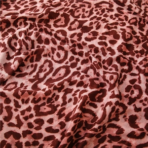 Detailed macro view of soft leopard print fabric texture with pink and brown patterns