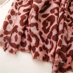 Detail of pink and brown leopard print scarf featuring soft texture and fringed edges