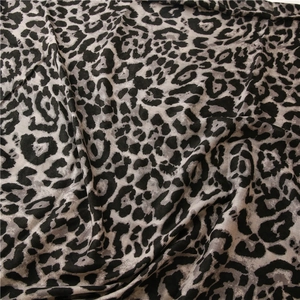 Close-up of leopard print scarf fabric showing soft herringbone weave texture and pattern