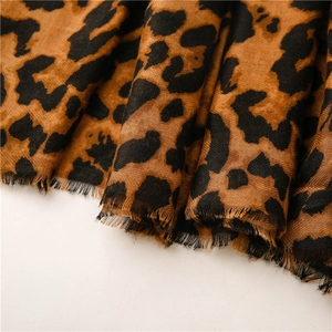 Close-up detail of leopard print scarf showing linen texture and fringe edges