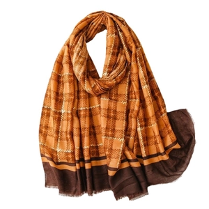 Linen-feel shawl scarf with gold foil grid pattern and frayed edges in orange brown