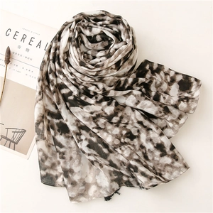 Macro detail of abstract tie-dye cotton linen scarf with soft braided fringe and elegant texture