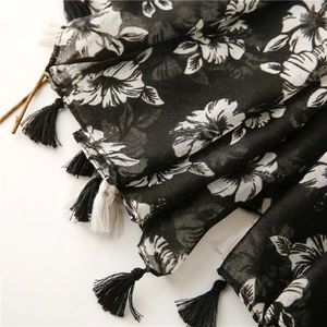 Close-up of lightweight floral scarf showing black and white tassels and soft fabric