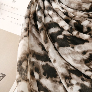 Close-up of leopard print scarf fabric showing soft cotton linen texture and fine draping