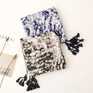 Detail of soft cotton linen scarves with tie-dye patterns and tassels for women