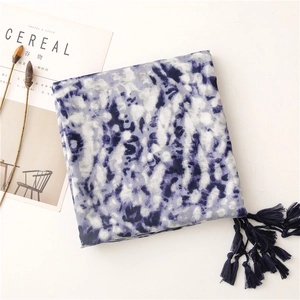 Detailed view of tie-dye cotton scarf with deep blue patterns and tassel trim details