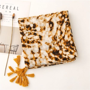 Flat lay view of leopard print scarf with yellow tassels next to aesthetic lifestyle props