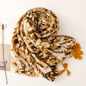 Detail of leopard print scarf with soft texture and yellow corner tassel accents