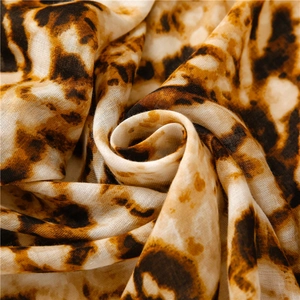 Detail shot of leopard print scarf fabric showing soft texture and woven patterns