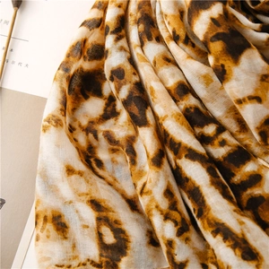 Detailed close-up of lightweight leopard print scarf with soft texture and artistic aesthetic