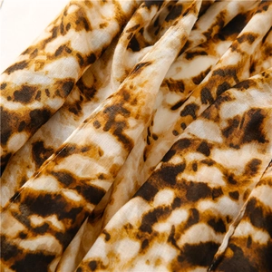 Close-up of leopard print lightweight chiffon fabric with brown and yellow animal patterns