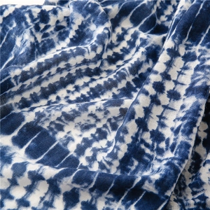 Detailed close-up of blue and white tie-dye cotton-linen fabric with woven texture