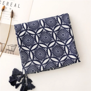 Detail of dark blue mandala pattern scarf with tassels on vintage magazine background
