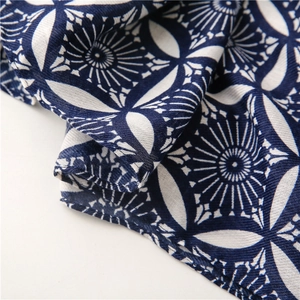 Detailed close-up of blue and white geometric floral print on a soft cotton scarf