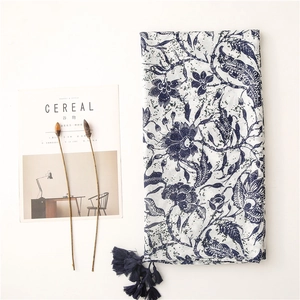 Vintage blue floral print cotton scarf with tassel fringe on a white background