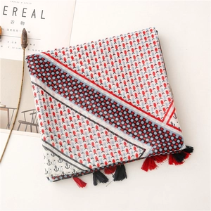 Detail of nautical cotton linen scarf with tassels, anchor patterns and navy fish prints