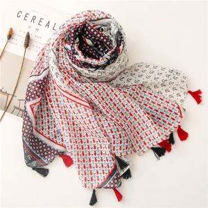 Detailed view of nautical anchor patterns and dot print with tassels on a soft scarf