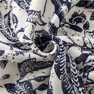 Macro shot of ethnic floral patterns and leaf textures on white cotton linen fabric